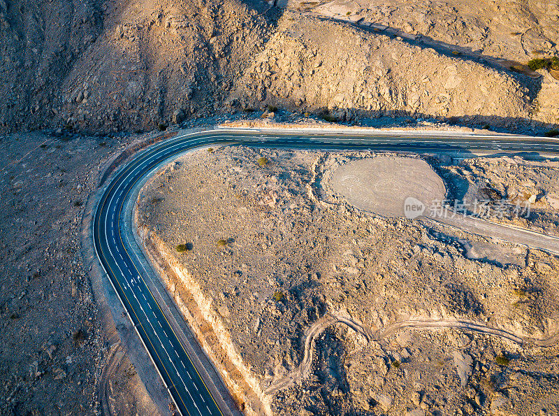 蜿蜒的沙漠道路在杰贝尔贾伊斯砂岩山在Ras Al Khaimah酋长国或阿联酋